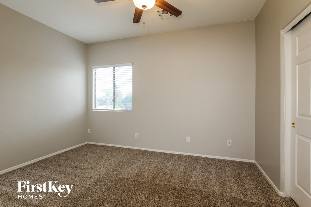 a empty room with a ceiling fan and a window
