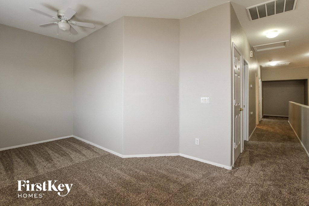 a living room with carpet and a ceiling fan