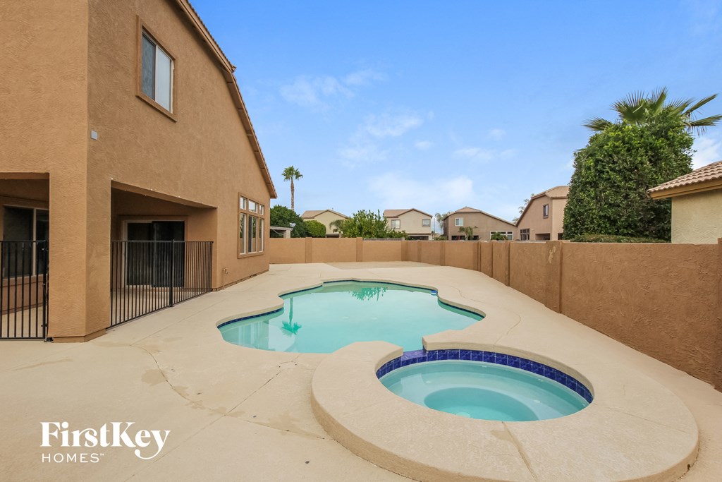 a pool and spa in the backyard of a house