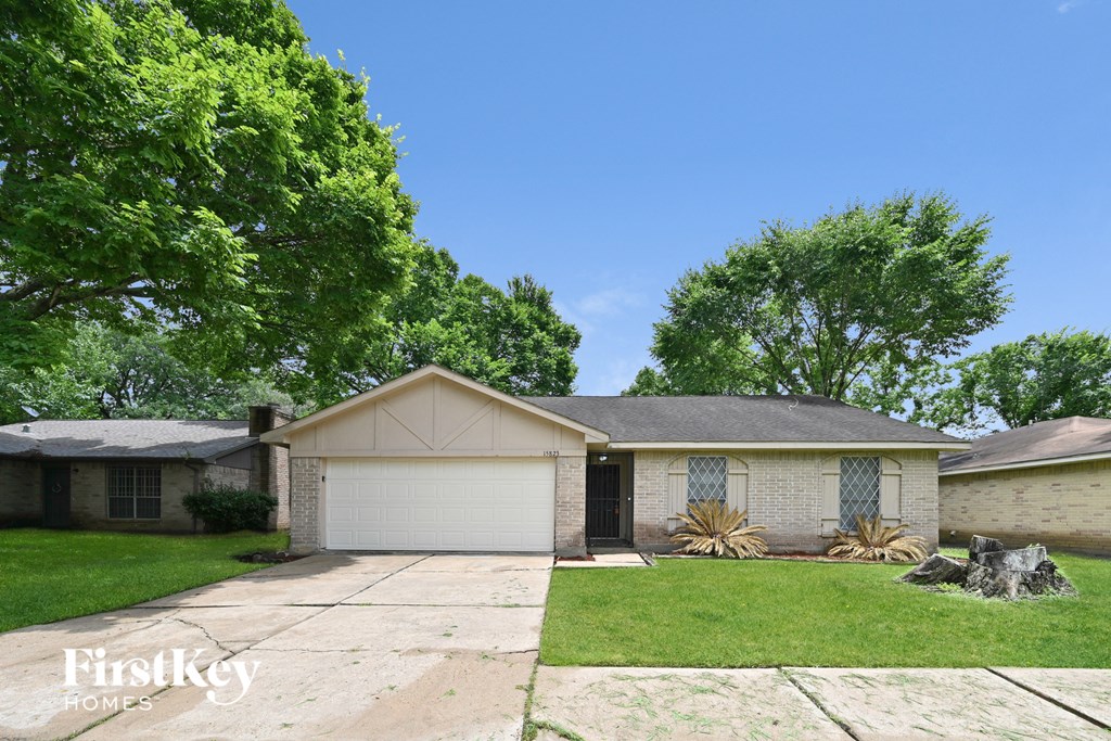 a white brick house with a black door and a lawn