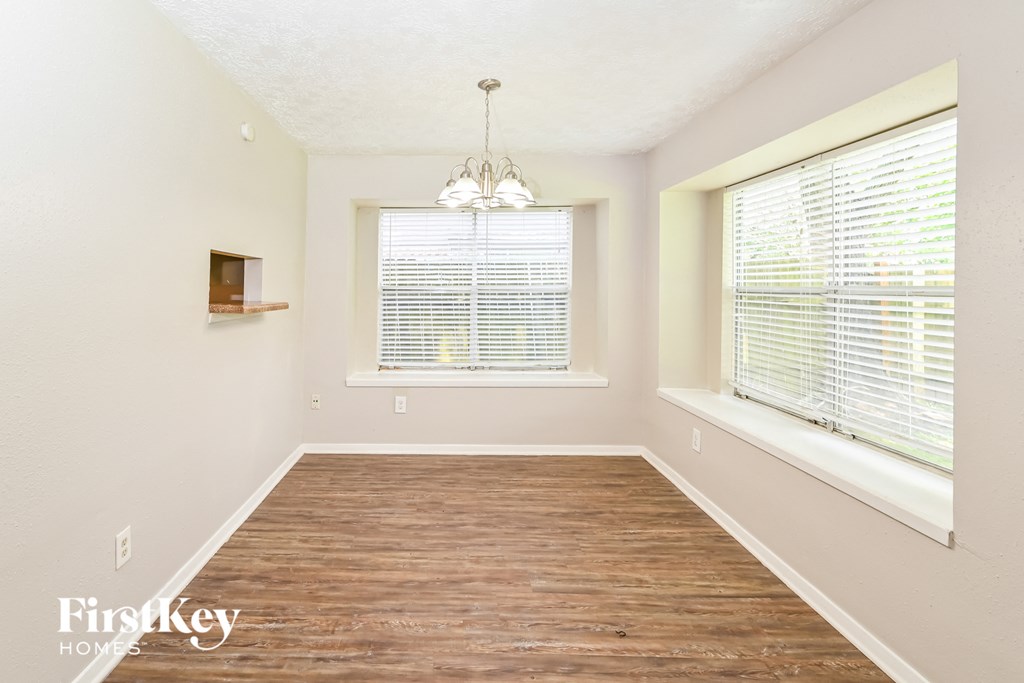 a living room with a large window and a wooden floor