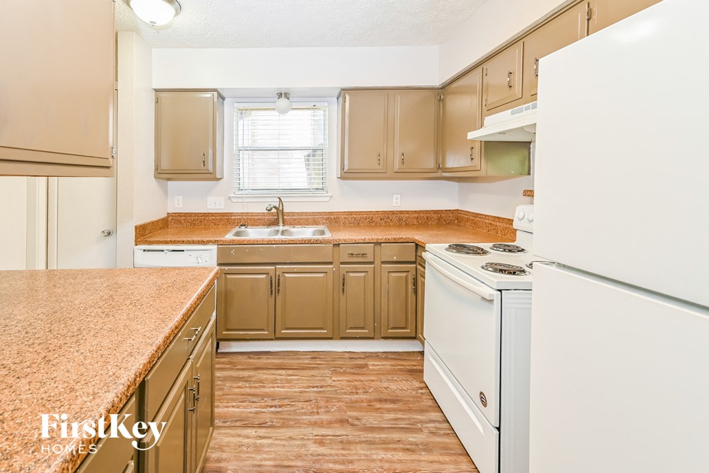 a kitchen with white appliances and brown counter tops