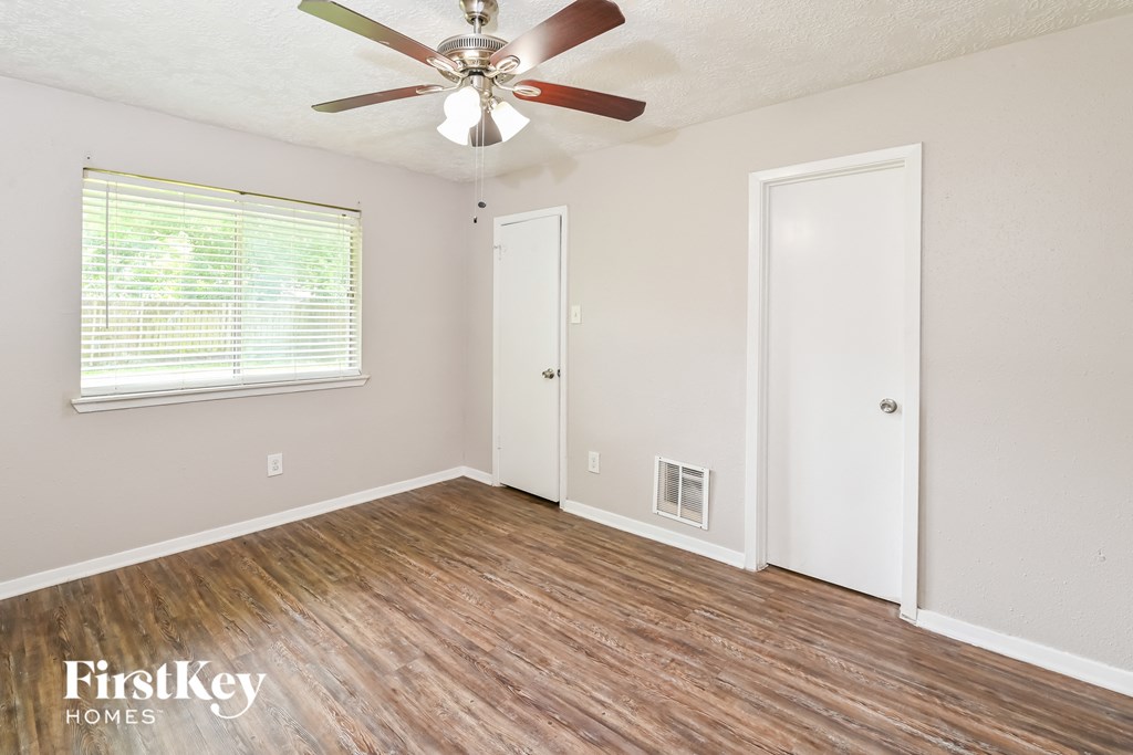 the living room of an empty house with a ceiling fan