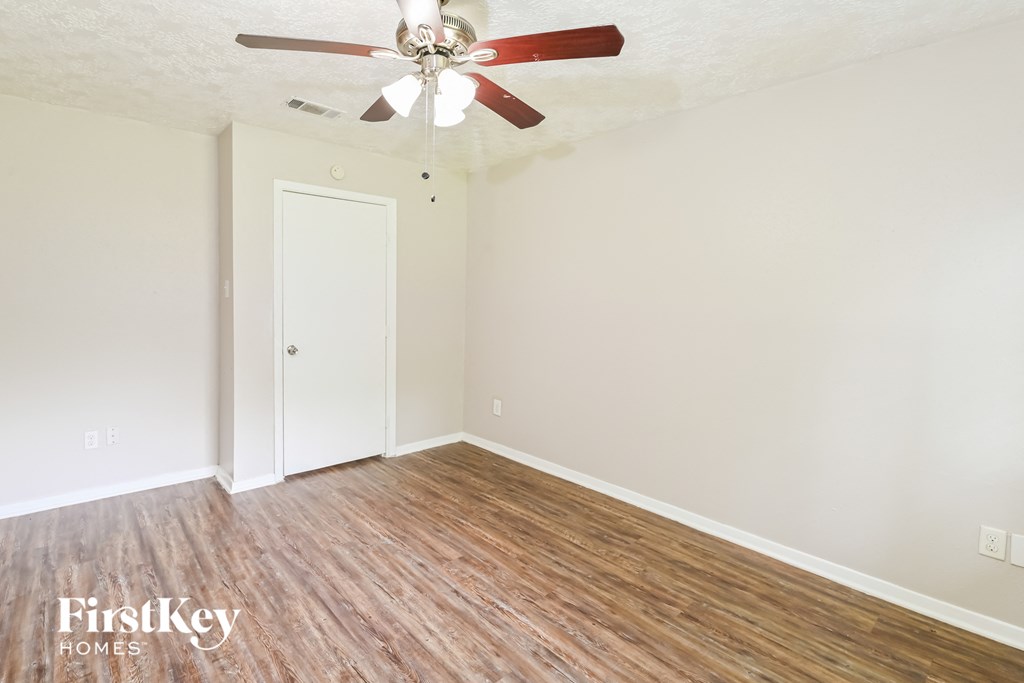 a living room with wood flooring and a ceiling fan