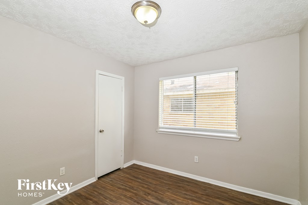 the living room of a small white house with a window and a door