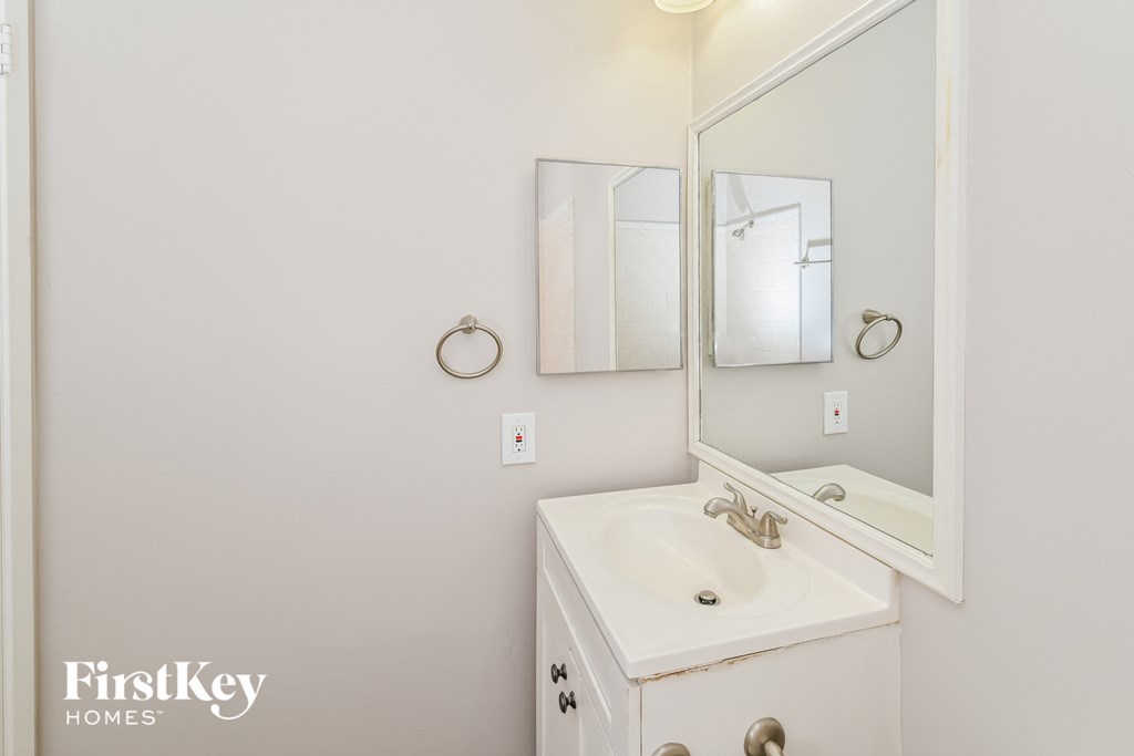 a white bathroom with a sink and a mirror