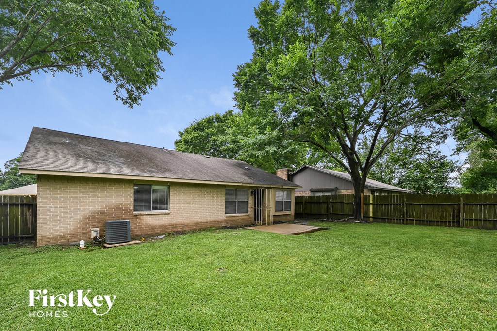 a brick house with a yard and a wooden fence
