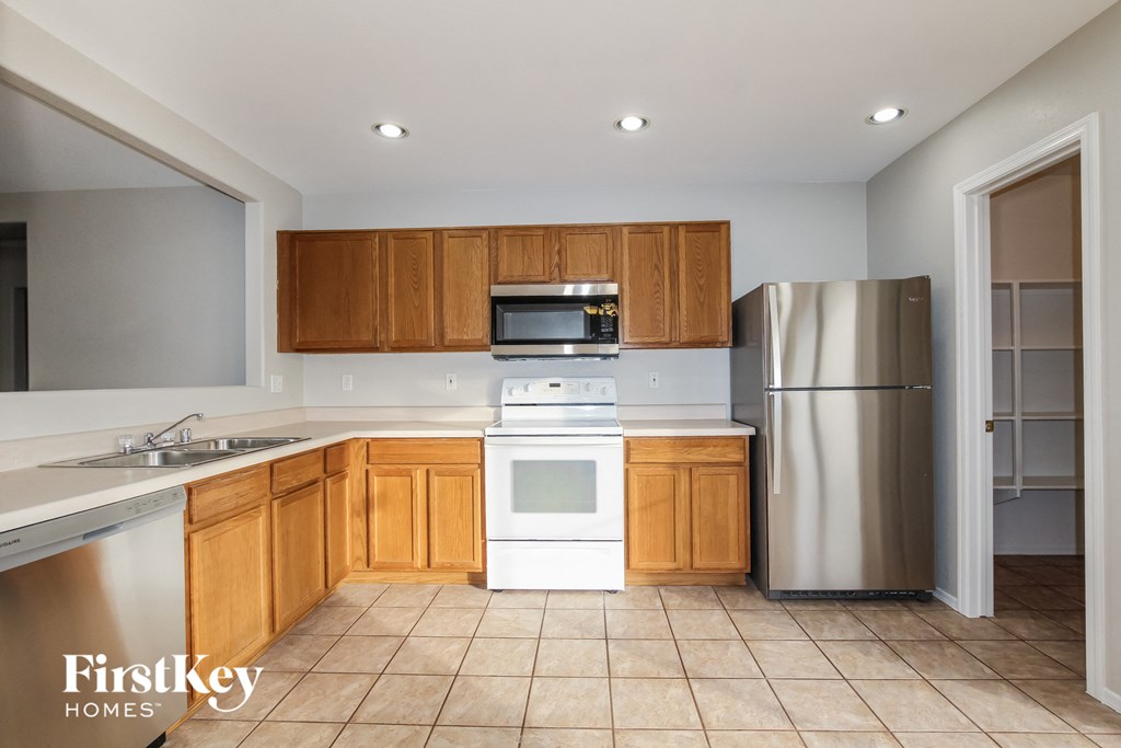 an empty kitchen with wooden cabinets and stainless steel appliances