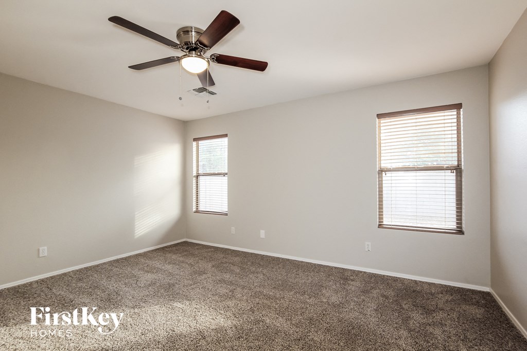 a living room with carpet and a ceiling fan