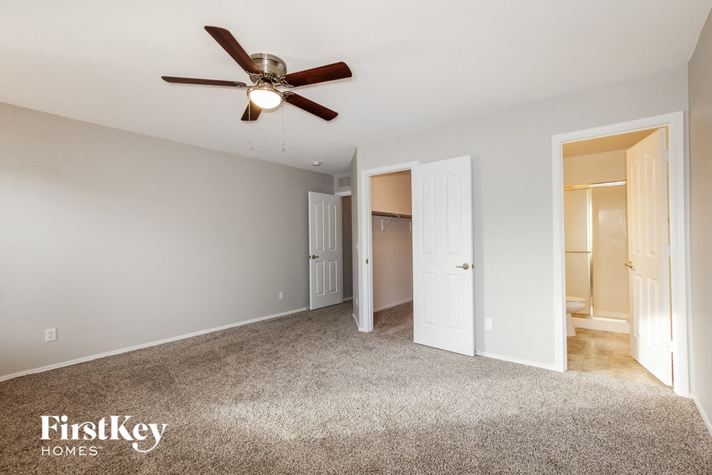 a bedroom with a ceiling fan and a closet