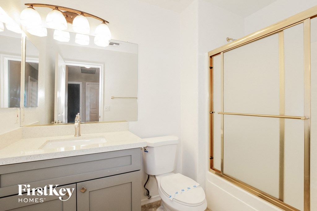 a bathroom with a sink toilet and shower and a mirror
