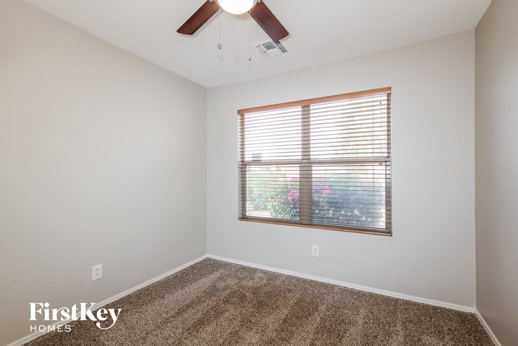 a bedroom with a window and a ceiling fan
