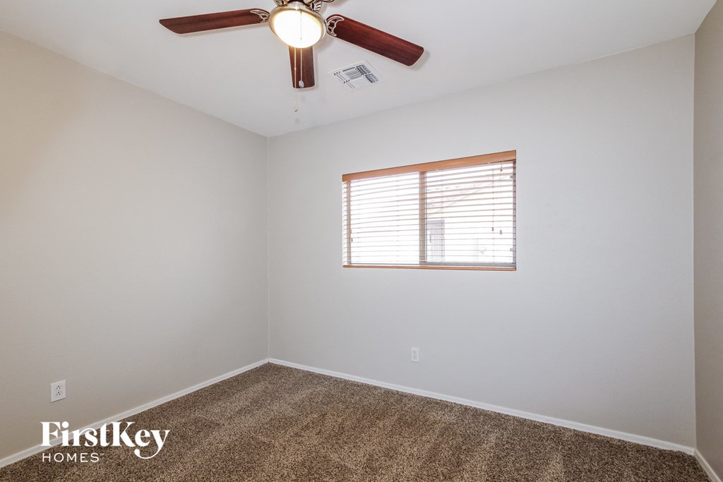 a bedroom with a ceiling fan and a window