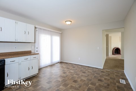 A kitchen with white cabinets and a checkered floor.