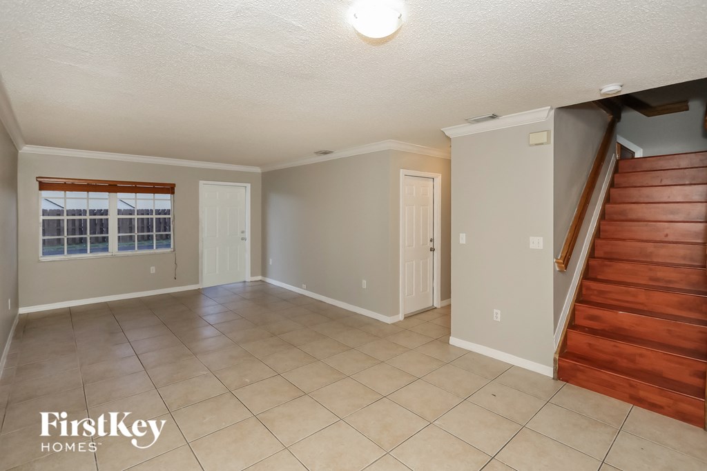 a living room with a staircase and a tile floor