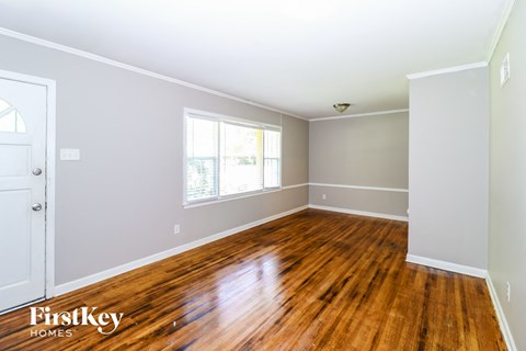 the living room of a house with wooden floors and a window
