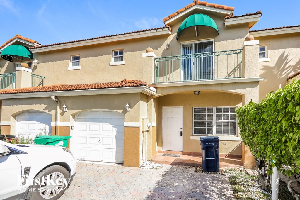 a house with two garages and a car parked in front of it