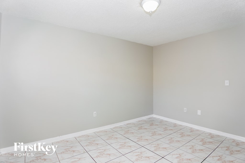 a empty room with a tile floor and grey walls