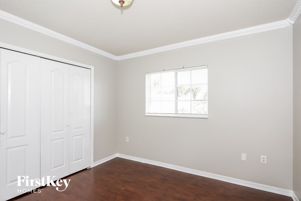 a bedroom with white walls and a white door and a window