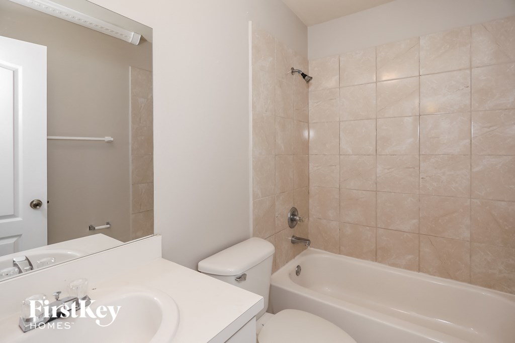 a white bathroom with a tub and a toilet and a sink