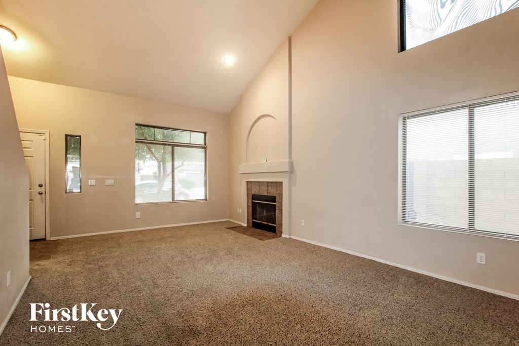 the living room has a fireplace and carpeted flooring and a large window