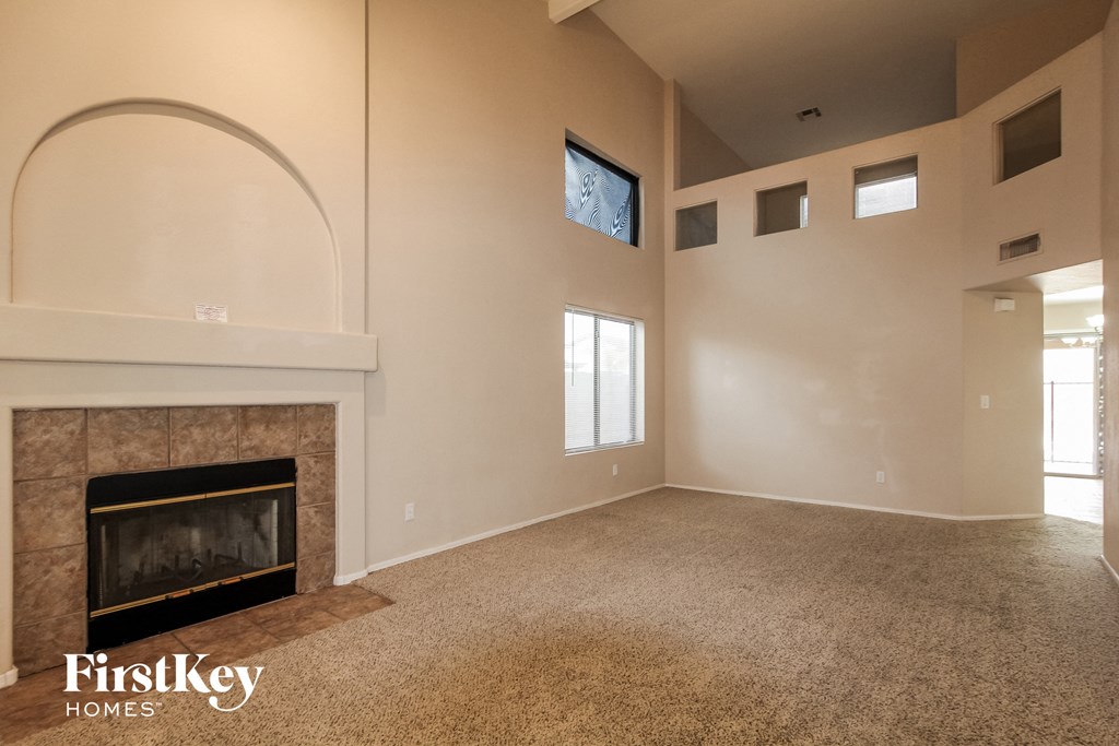 the living room of an empty house with a fireplace