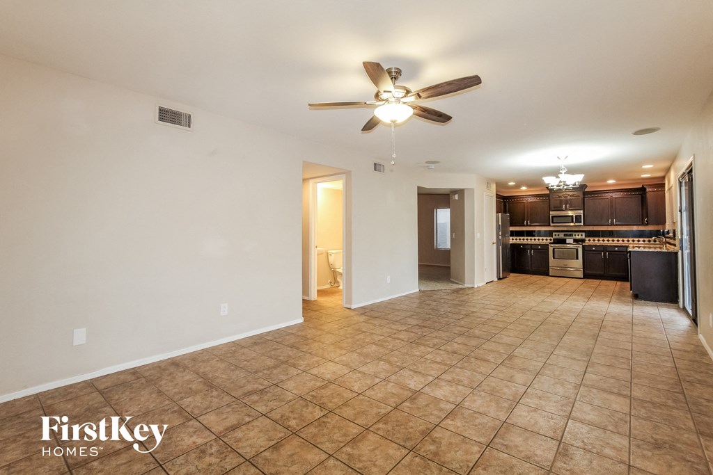 an empty kitchen and living room with a ceiling fan