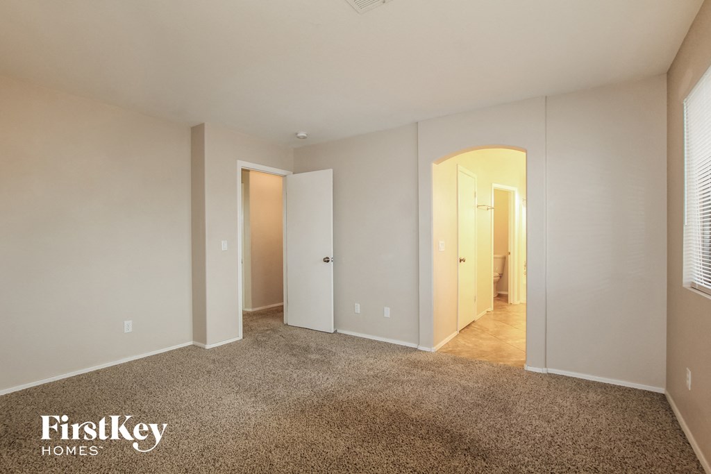 a master bedroom with a carpeted floor and white walls