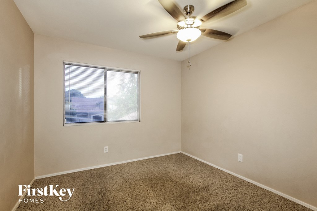 a bedroom with a ceiling fan and a window