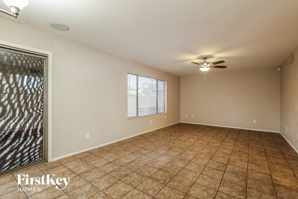 the living room of an empty house with a ceiling fan