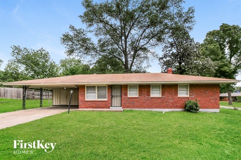 A red brick house with a white door and a small porch.