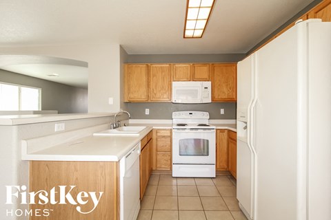 a kitchen with white appliances and wooden cabinets