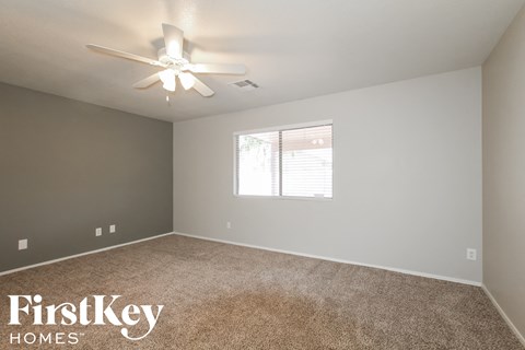 a bedroom with a ceiling fan and a window