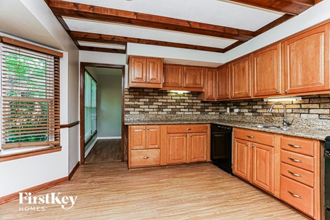 A kitchen with wooden cabinets and a brick backsplash.