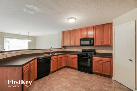 a kitchen with wooden cabinets and black appliances