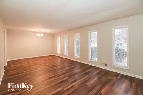 a living room with a hardwood floor and windows