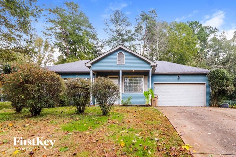 a blue house with a driveway and a garage door