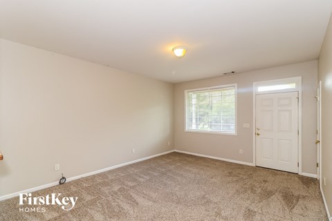 the master bedroom is spacious and clean with carpeted flooring and a white door