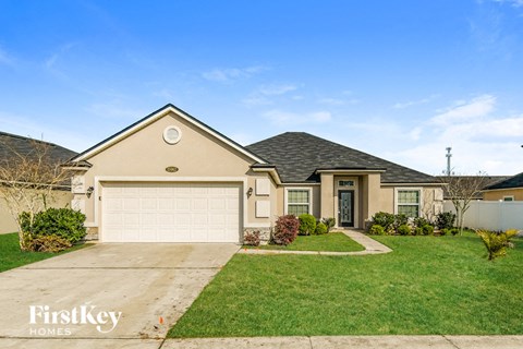a beige house with a garage and a lawn
