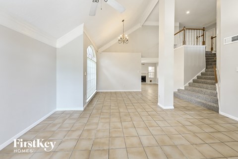 a large living room with a staircase and a tile floor