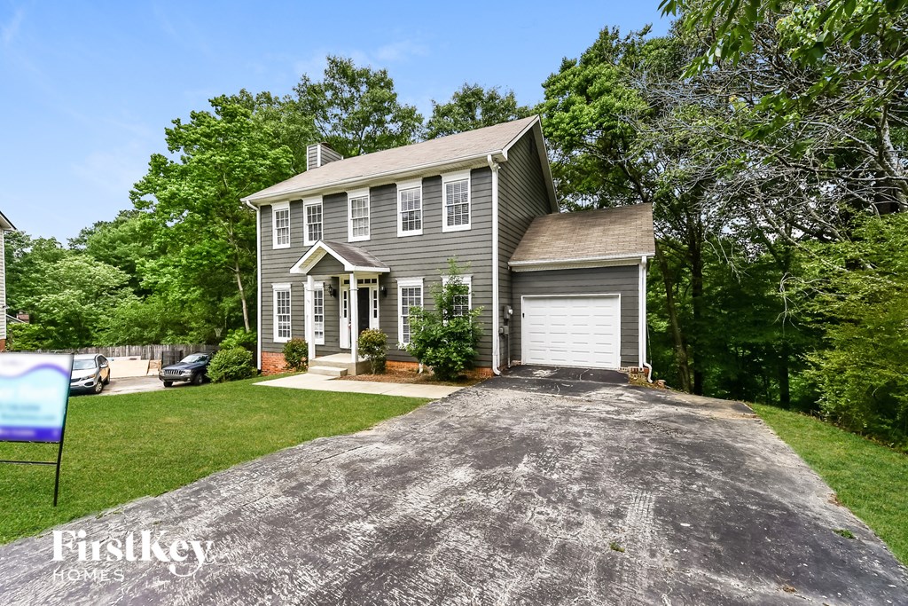 a gray house with a driveway and a white garage door