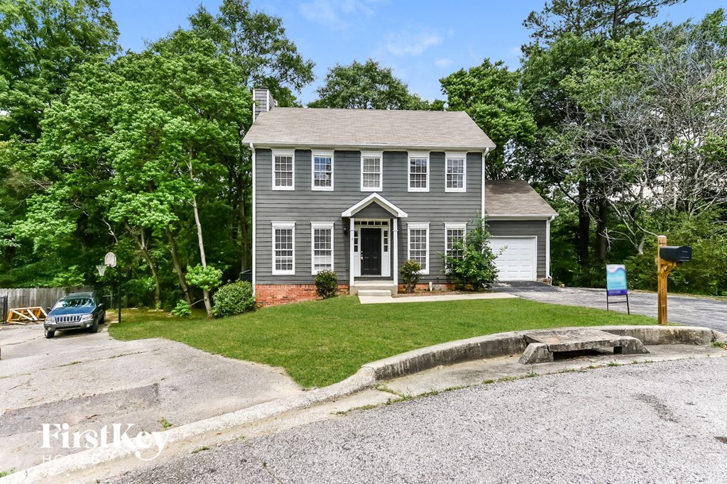 a gray house with a lawn and a driveway