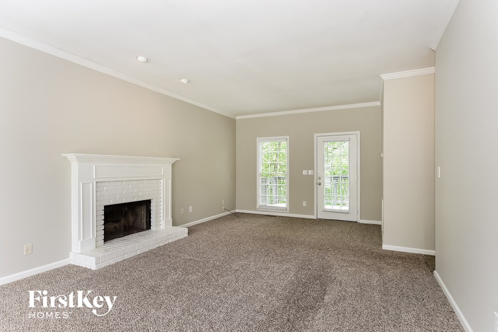 a living room with a fireplace and a carpeted floor