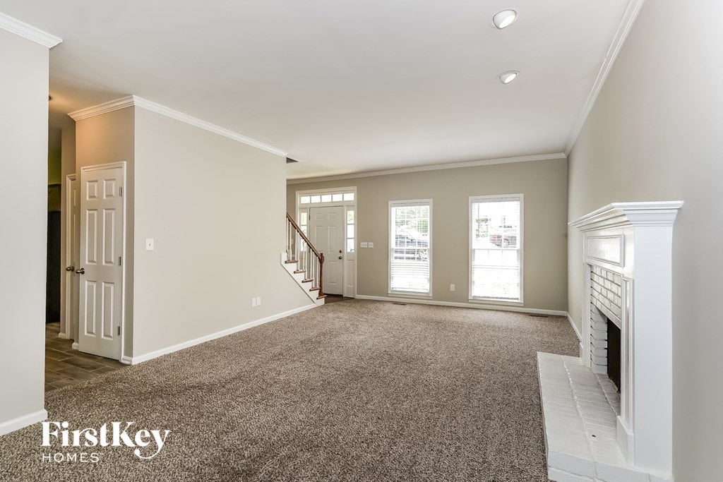 a living room with a fireplace and a carpeted floor