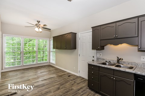 a kitchen and living room with dark cabinets and a large window