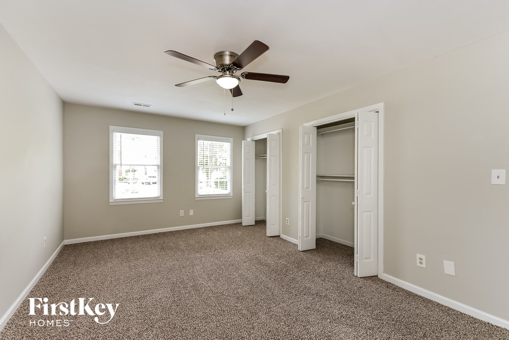 a bedroom with a ceiling fan and a closet