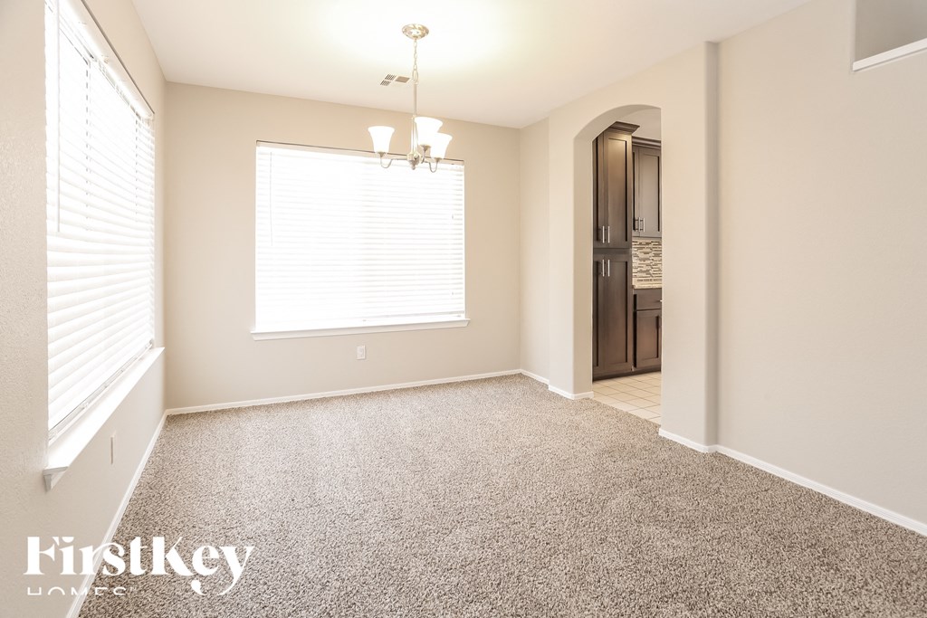 an empty living room with a large window and carpet