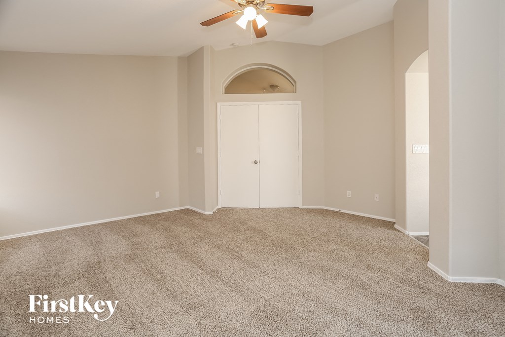 a empty room with a ceiling fan and a white door