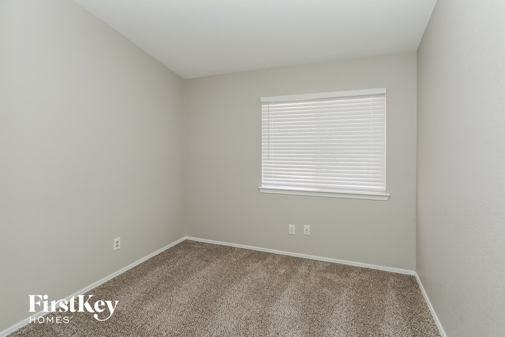 a spacious room with carpet and a window