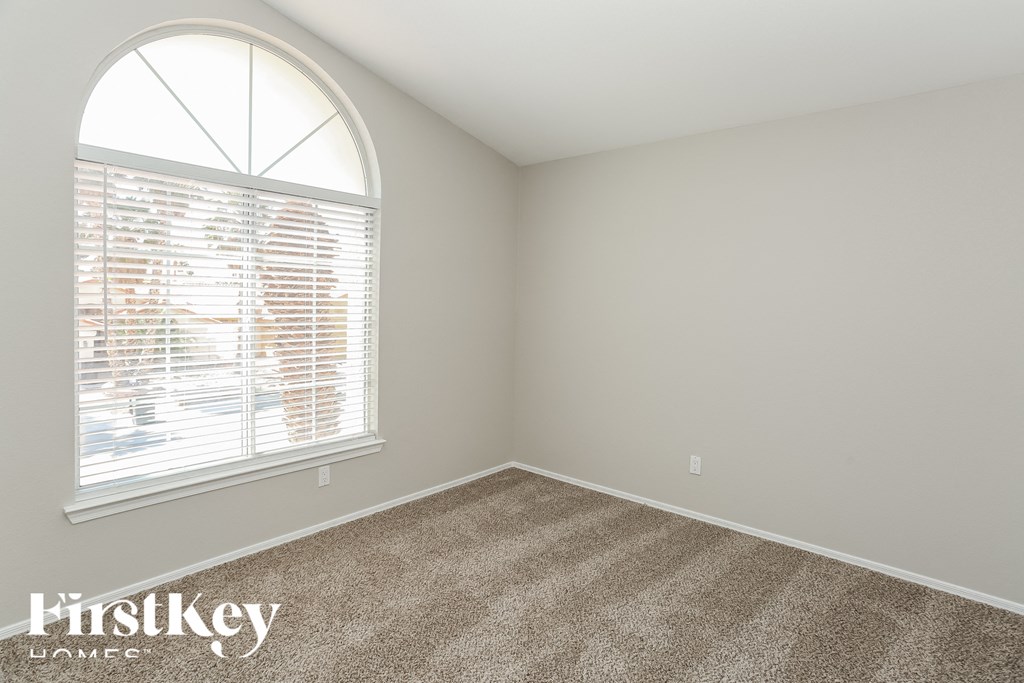 the second bedroom has a large window and carpet